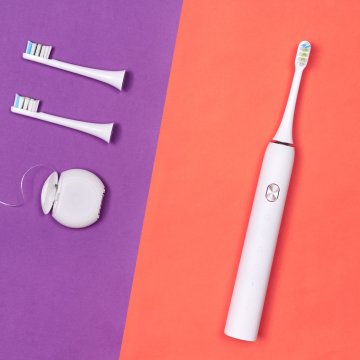 Toothbrush with additional heads on a purple and red background